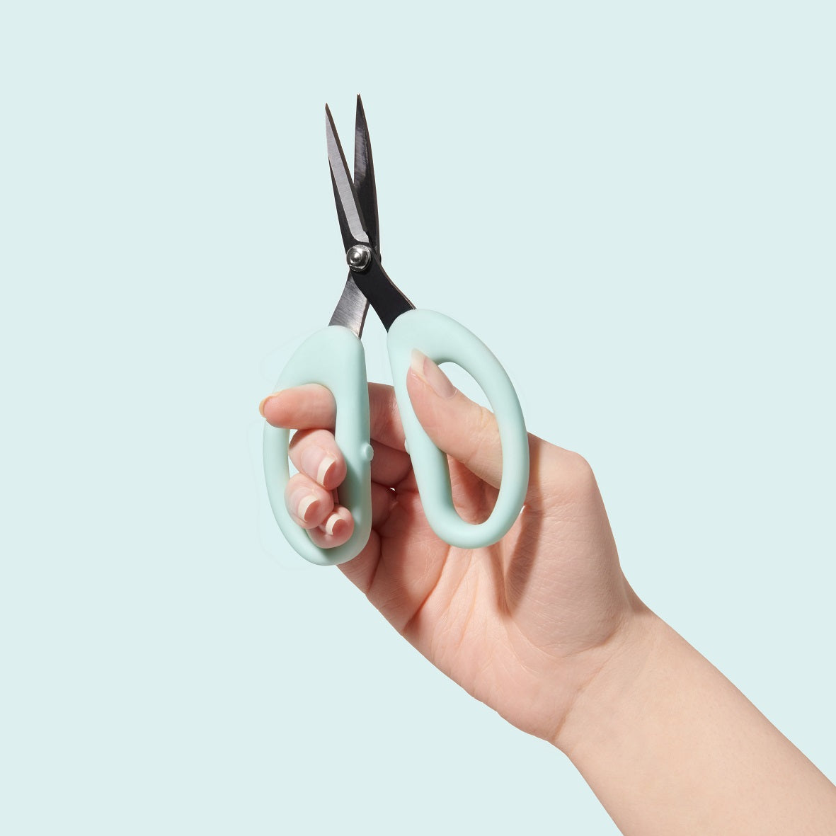 Hand holding SOHMO Go-To medium blue craft scissors