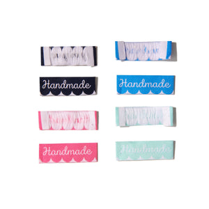 sew-in garment labels with 'handmade' text on scallop background