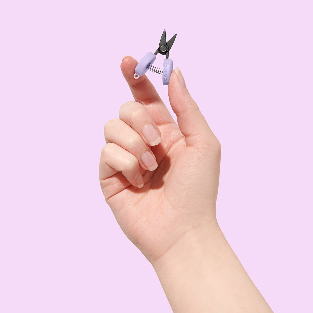 A small pair of aeroplane approved scissors held in a hand