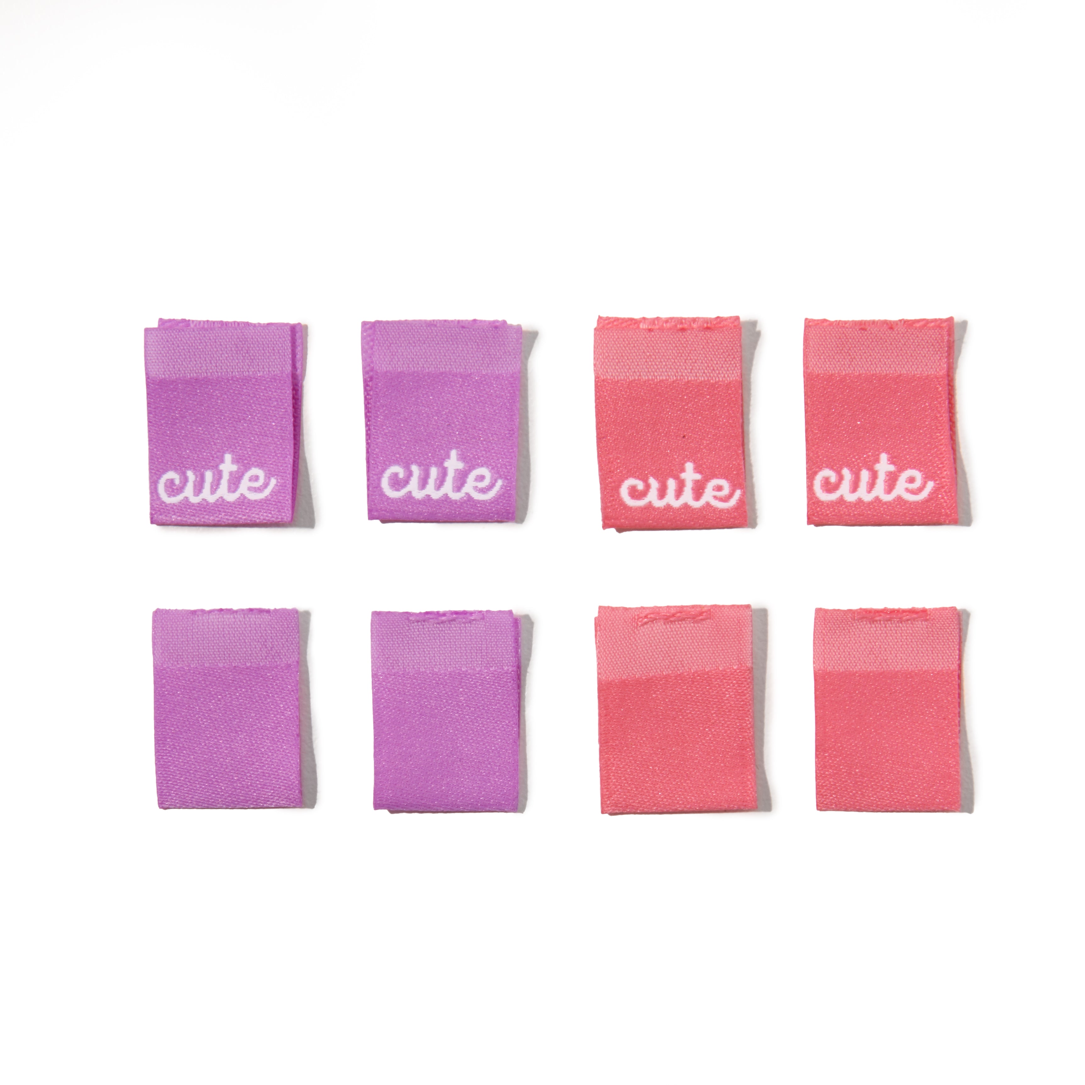 Set of eight pink and purple sew-in clothing labels with 'cute' text on a white background